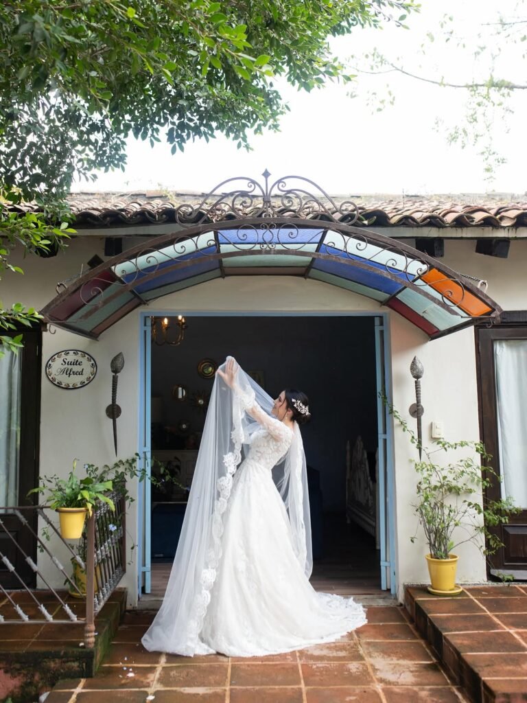 Novia con velo en la entrada de la hacienda
